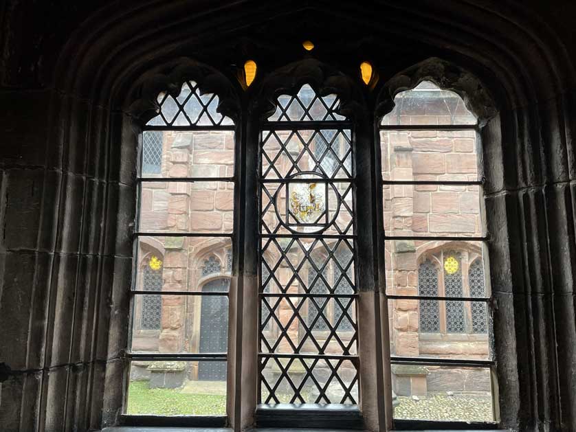 A view through a stained glass window into the courtyard.