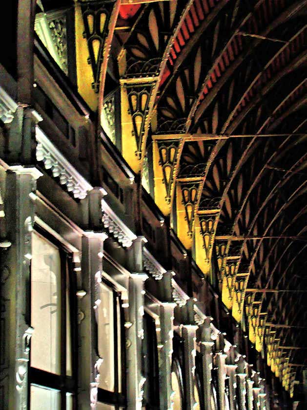 Wrought iron pillars and curved girders support the glazed roof of Paddington Station.