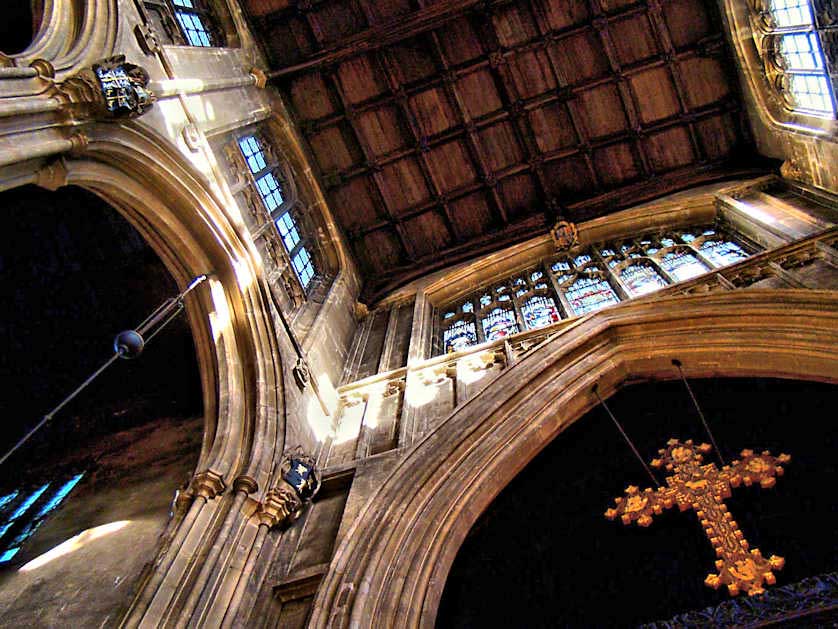A large cross hangs from the Chancel Arch, the oldest part of St. John the Baptist Church in Cirencester.