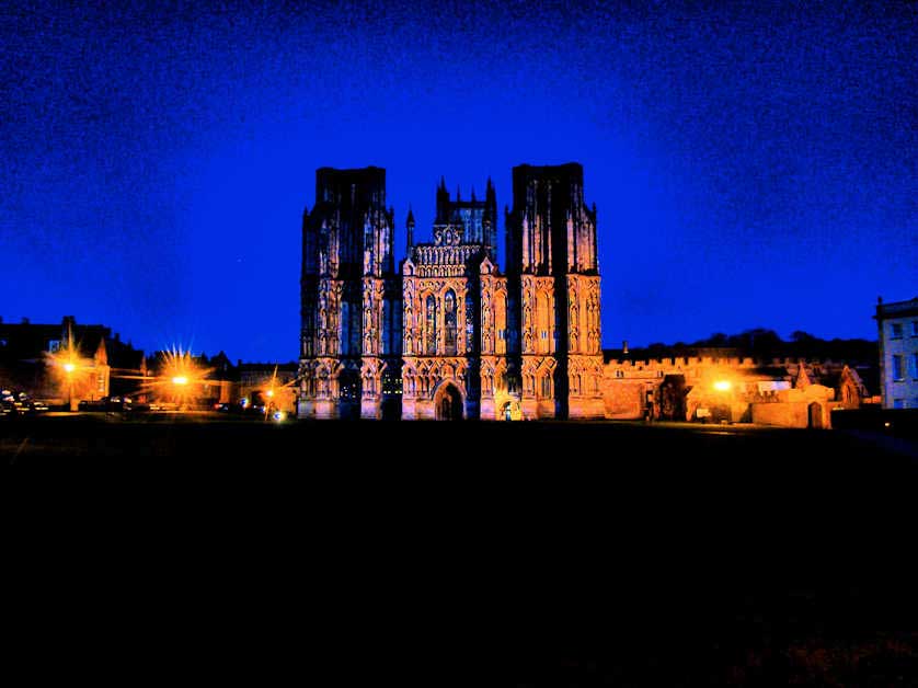 Illuminated at night, Wells Cathedral viewed from across Cathedral Green.
