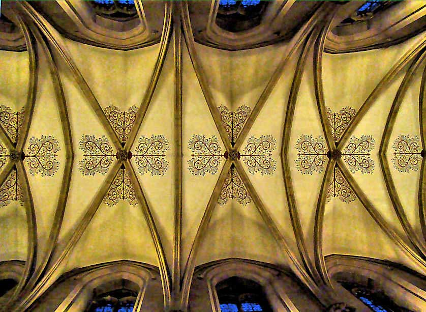 The vaulted-arch ceiling, more than 20 meters above the floor of the  nave of Wells Cathedral. The decoration was added in the 19th century.