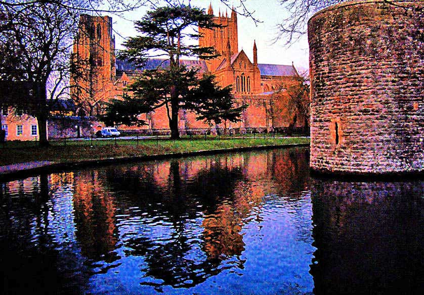 Wells Cathedral at sunset reflected in the moat of the Bishop's Palace.